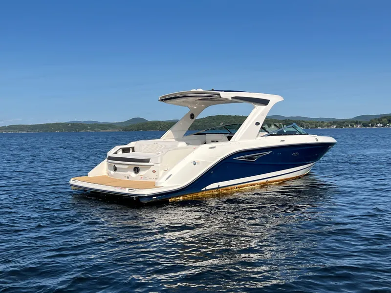 Slide: The Image of 2019 Sea Ray SLX 310 boat on a calm lake under clear blue skies. - 40