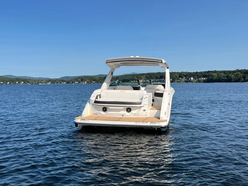 Slide: The Image of 2019 Sea Ray SLX 310 boat on a serene lake with clear blue skies. - 42