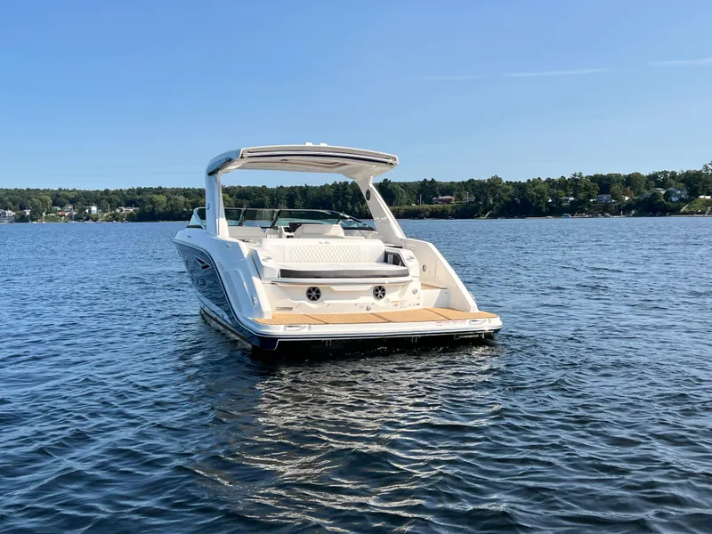 Slide: The Image of 2019 Sea Ray SLX 310 boat on a calm lake under clear blue sky. - 45