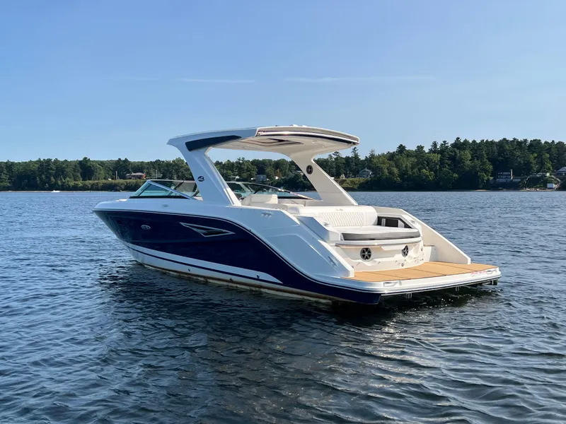 Slide: The Image of 2019 Sea Ray SLX 310 boat on a serene lake with forested shoreline. - 47