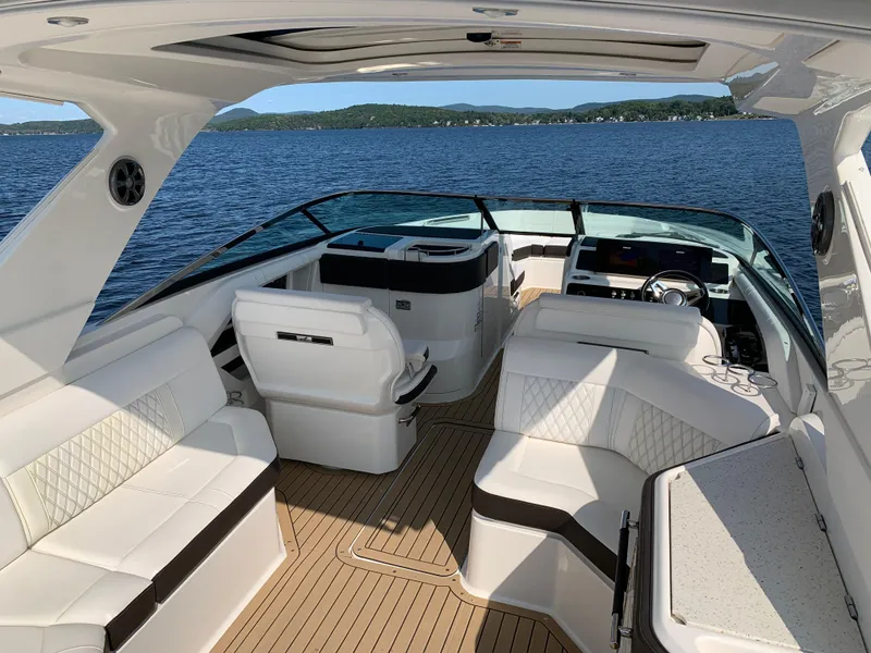 Slide: The Image of 2019 Sea Ray SLX 310 boat interior with luxurious seating on a serene lake. - 8