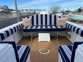 Slide: The Image of 2025 Steiger Craft 255 Annapolis boat interior with striped seating and wooden deck. - 15