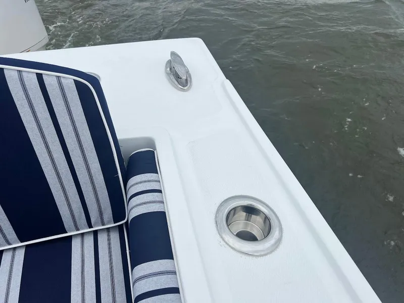 Slide: The Image of 2025 Steiger Craft 255 Annapolis boat with striped seating and cup holder on deck. - 16