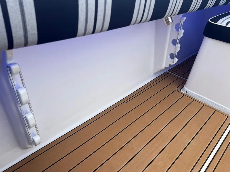 Slide: The Image of 2025 Steiger Craft 255 Annapolis interior with striped seating and wood-style flooring. - 17