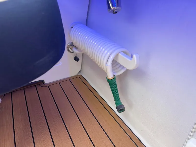 Slide: The Image of Coiled hose on 2025 Steiger Craft 255 Annapolis boat with teak flooring. - 18