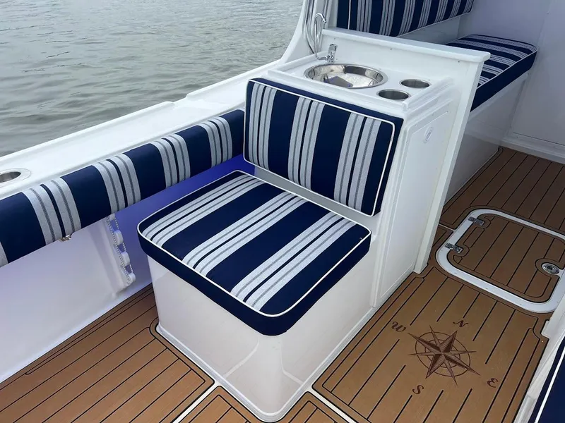 Slide: The Image of Steiger Craft 255 Annapolis 2025 boat interior with striped seating and compass-themed flooring. - 19