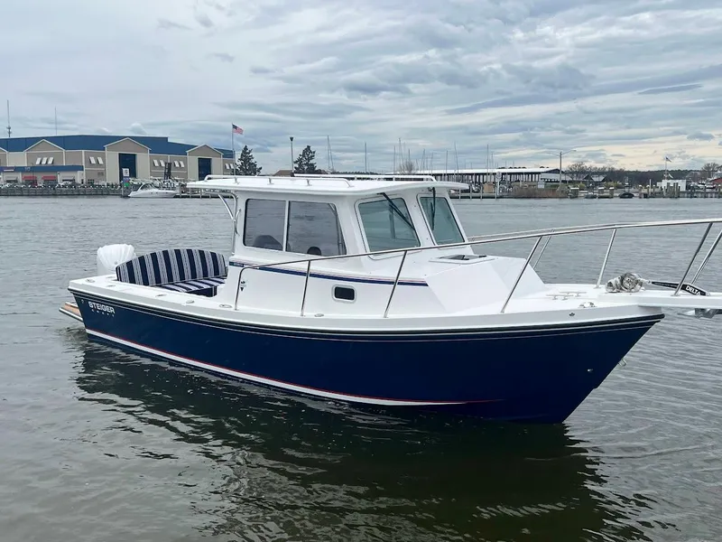 Slide: The Image of 2025 Steiger Craft 255 Annapolis boat on calm water, overcast sky. - 2