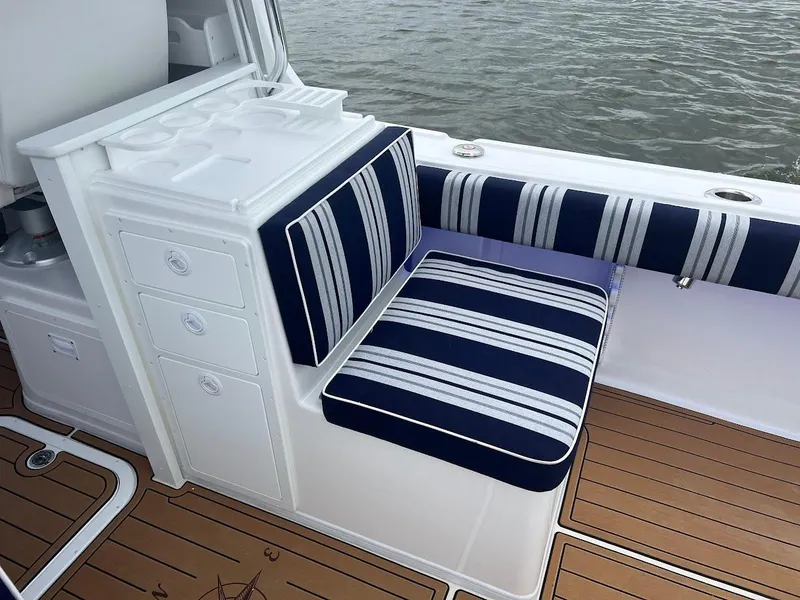 Slide: The Image of Steiger Craft 255 Annapolis 2025 boat interior with striped seating and wooden deck. - 20