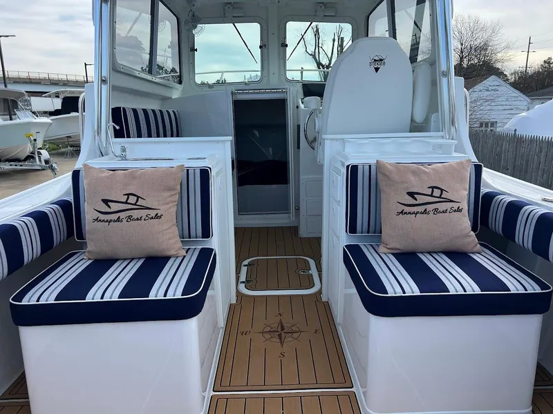 Slide: The Image of 2025 Steiger Craft 255 Annapolis boat interior with striped seating and nautical-themed cushions. - 21