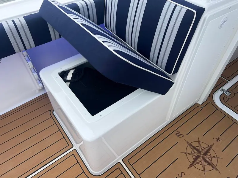 Slide: The Image of Steiger Craft 255 Annapolis 2025 boat seating with storage, compass design on deck. - 24