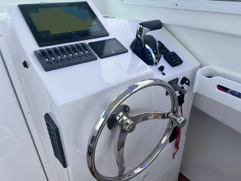 Slide: The Image of Steiger Craft 255 Annapolis 2025 helm with steering wheel and navigation controls. - 35