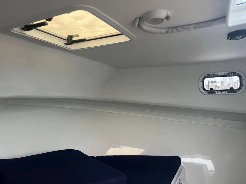 Slide: The Image of Interior cabin of 2025 Steiger Craft 255 Annapolis boat, featuring a skylight and window. - 44