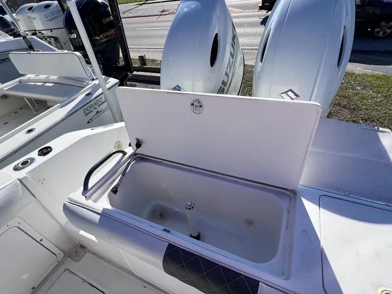 Slide: The Image of Open storage compartment on a 1997 Dakota 32 cc Suzuki boat, with visible outboard motors. - 23