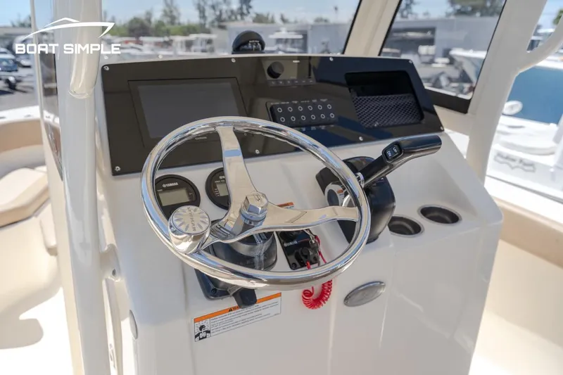 Slide: The Image of 2023 Scout 215 XSF boat helm with steering wheel and control panel. - 4