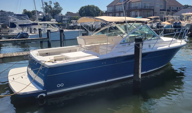 Slide: The Image of 2006 Tiara Yachts 2900 Coronet docked in a marina, blue hull, beige canopy. - 6