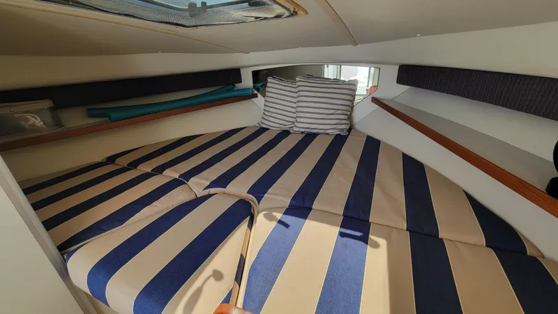 Slide: The Image of 2006 Tiara Yachts 2900 Coronet cabin with striped bedding and pillows. - 23