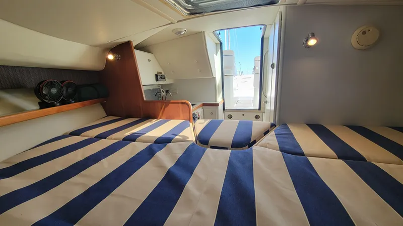 Slide: The Image of Interior of 2006 Tiara Yachts 2900 Coronet with striped bedding and natural light. - 22