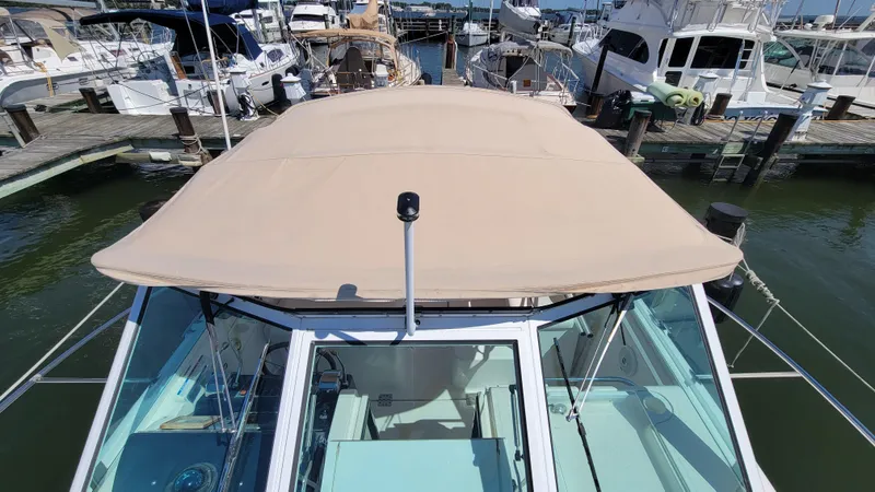 Slide: The Image of 2006 Tiara Yachts 2900 Coronet docked at marina, beige canopy, clear skies. - 10