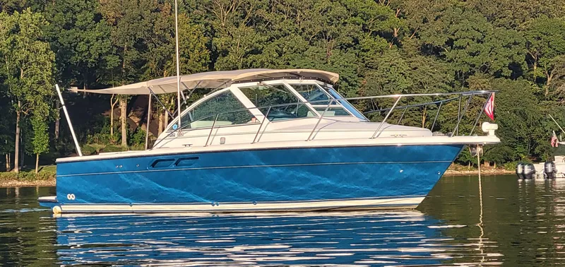 Slide: The Image of 2006 Tiara Yachts 2900 Coronet boat on calm water with forest background. - 1