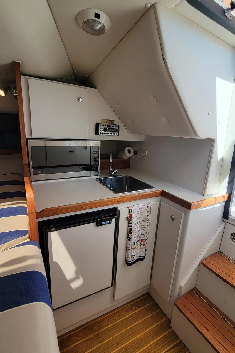 Slide: The Image of 2006 Tiara Yachts 2900 Coronet interior kitchen with sink, microwave, and mini-fridge. - 20