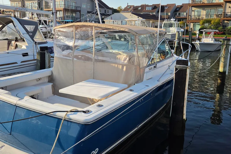 Slide: The Image of 2006 Tiara Yachts 2900 Coronet docked at marina, featuring blue hull and covered seating area. - 12