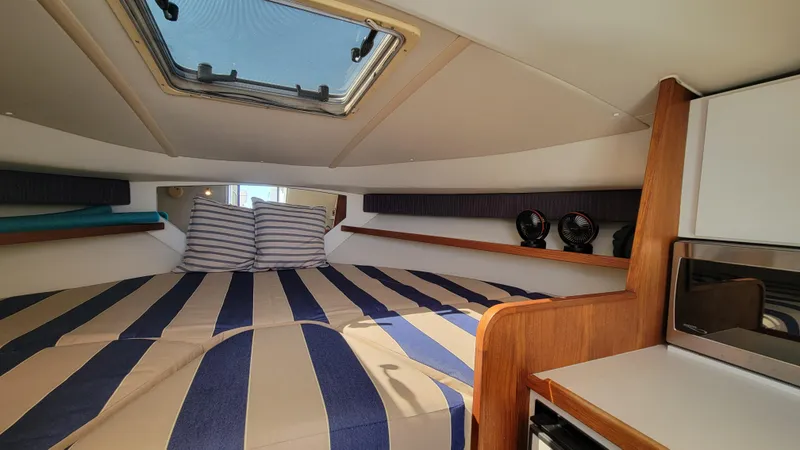 Slide: The Image of Interior cabin of 2006 Tiara Yachts 2900 Coronet with striped bedding and skylight. - 24
