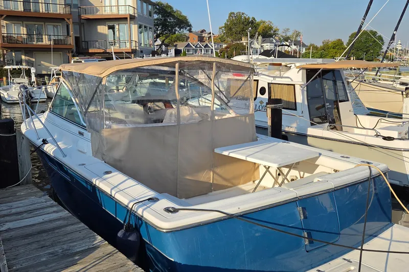 Slide: The Image of 2006 Tiara Yachts 2900 Coronet docked at a marina, featuring a blue hull and canopy. - 11