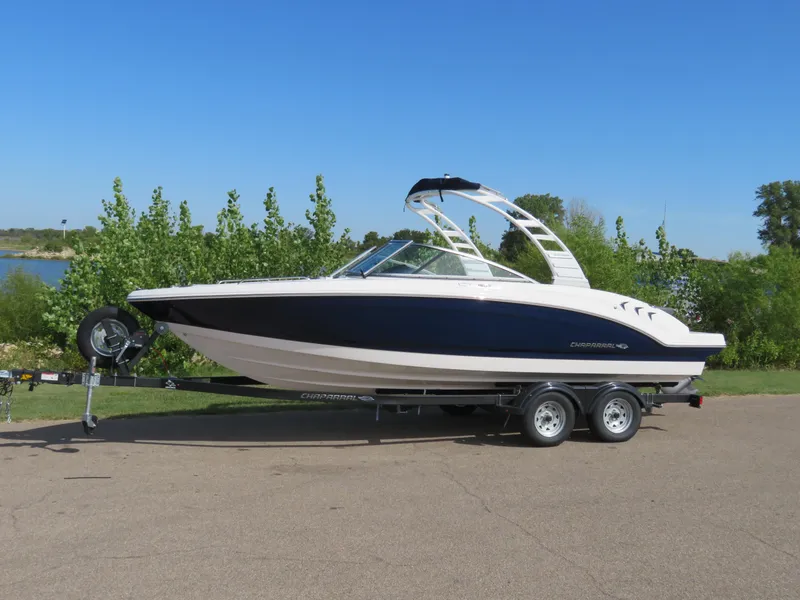 Slide: The Image of 2025 Chaparral 23 SSi boat on trailer, parked outdoors, clear blue sky. - 1