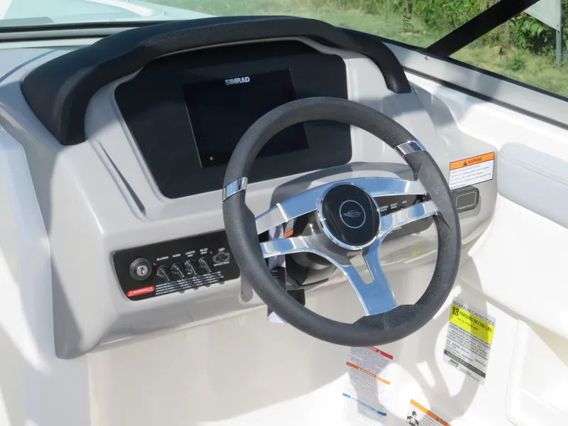 Slide: The Image of 2025 Chaparral 23 SSi boat dashboard with steering wheel and control panel. - 9