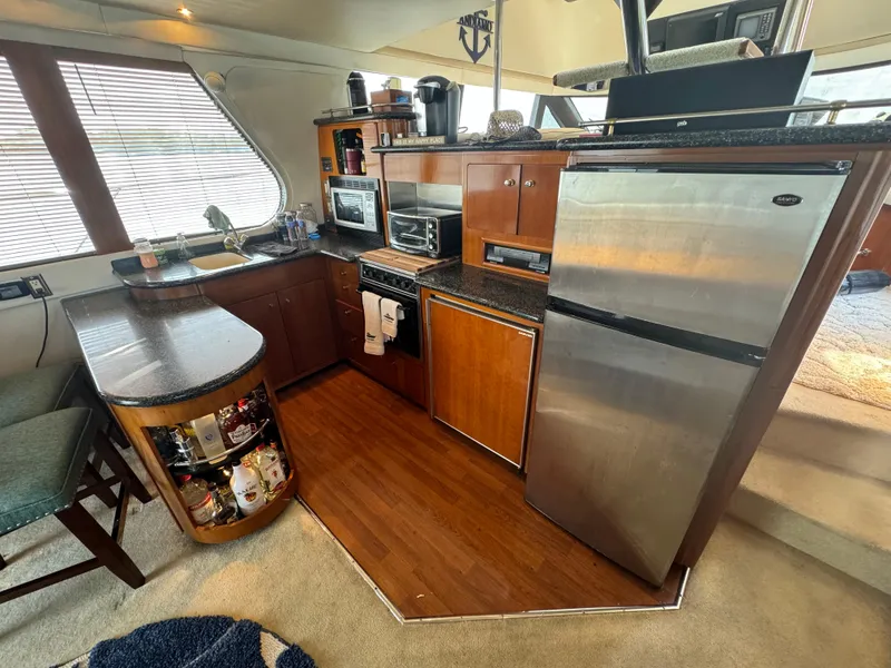 Slide: The Image of Kitchen area of 2000 Carver 530 Voyager Pilothouse with modern appliances and wood cabinetry. - 10