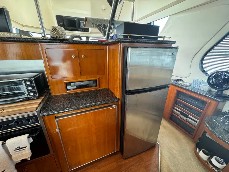 Slide: The Image of Interior of 2000 Carver 530 Voyager Pilothouse with kitchen appliances and wooden cabinetry. - 11