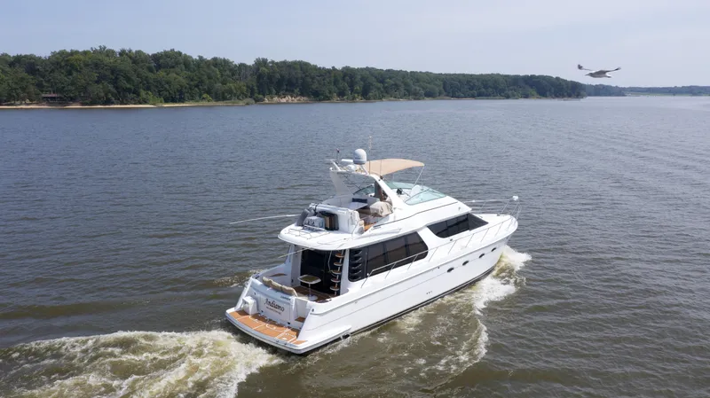 Slide: The Image of 2000 Carver 530 Voyager Pilothouse yacht cruising on a serene lake. - 2