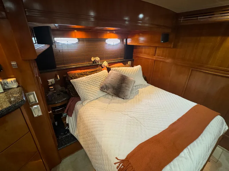 Slide: The Image of Luxurious bedroom in 2000 Carver 530 Voyager Pilothouse yacht with cozy bedding and wood paneling. - 28