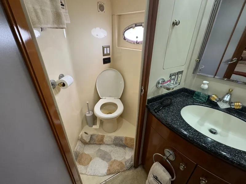 Slide: The Image of Bathroom in 2000 Carver 530 Voyager Pilothouse with toilet, sink, and porthole window. - 33