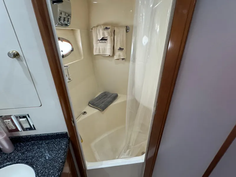 Slide: The Image of 2000 Carver 530 Voyager Pilothouse bathroom with shower, towels, and granite countertop. - 34