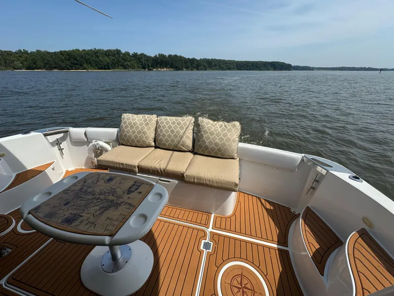 Slide: The Image of 2000 Carver 530 Voyager Pilothouse deck with seating, table, and scenic water view. - 7