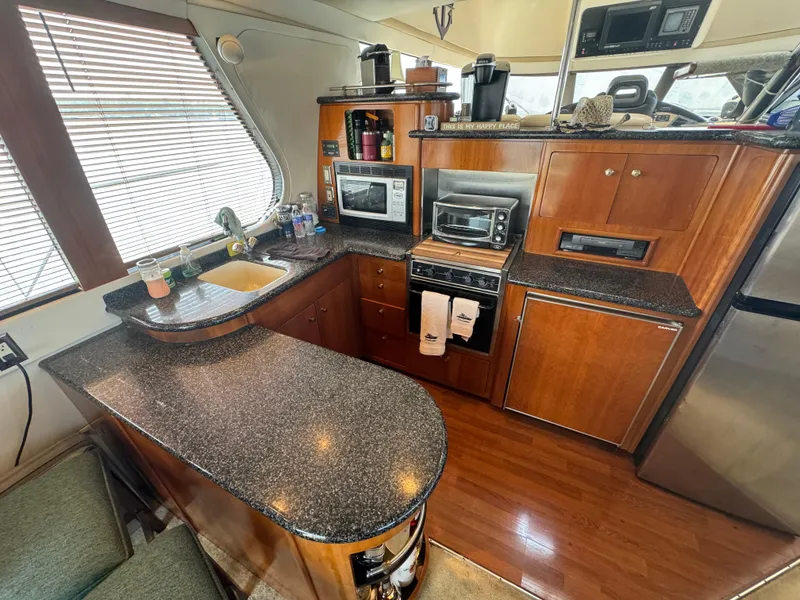 Slide: The Image of Kitchen area of 2000 Carver 530 Voyager Pilothouse with modern appliances and wood cabinetry. - 9