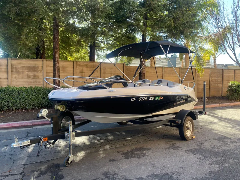Slide: The Image of 2015 Scarab 165 Standard boat on trailer, parked outdoors. - 0