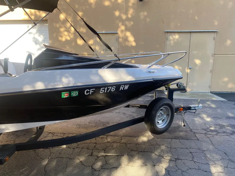 Slide: The Image of 2015 Scarab 165 Standard boat on trailer, parked outdoors. - 10