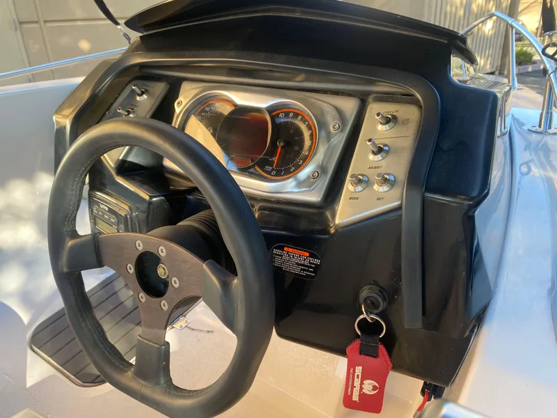 Slide: The Image of Dashboard of a 2015 Scarab 165 Standard boat with steering wheel and controls. - 12
