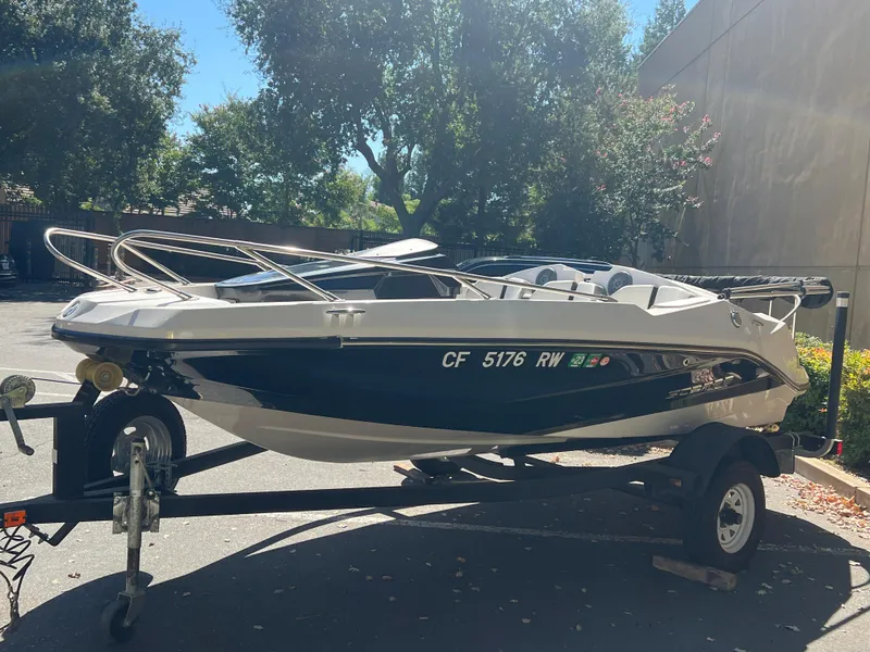 Slide: The Image of 2015 Scarab 165 Standard boat on trailer, parked outdoors in sunlight. - 25