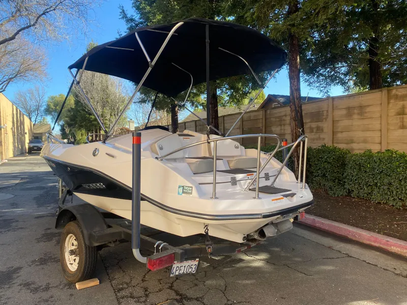 Slide: The Image of 2015 Scarab 165 Standard boat with canopy on trailer, parked on street. - 4
