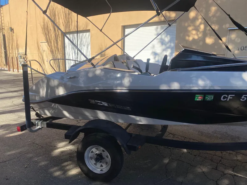 Slide: The Image of 2015 Scarab 165 Standard boat on trailer, parked outdoors with canopy. - 9