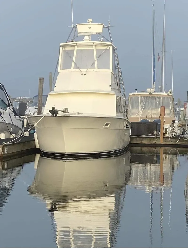 Slide: The Image of 1969 Hatteras 36 Sport Fisherman docked in a calm marina. - 10
