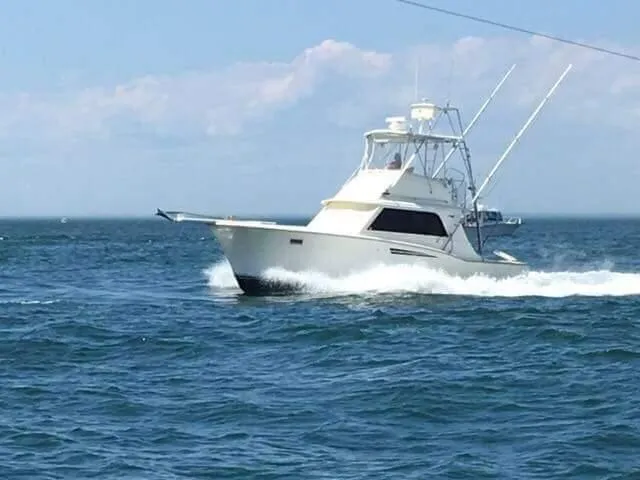 Slide: The Image of 1969 Hatteras 36 Sport Fisherman cruising on open sea under clear skies. - 11