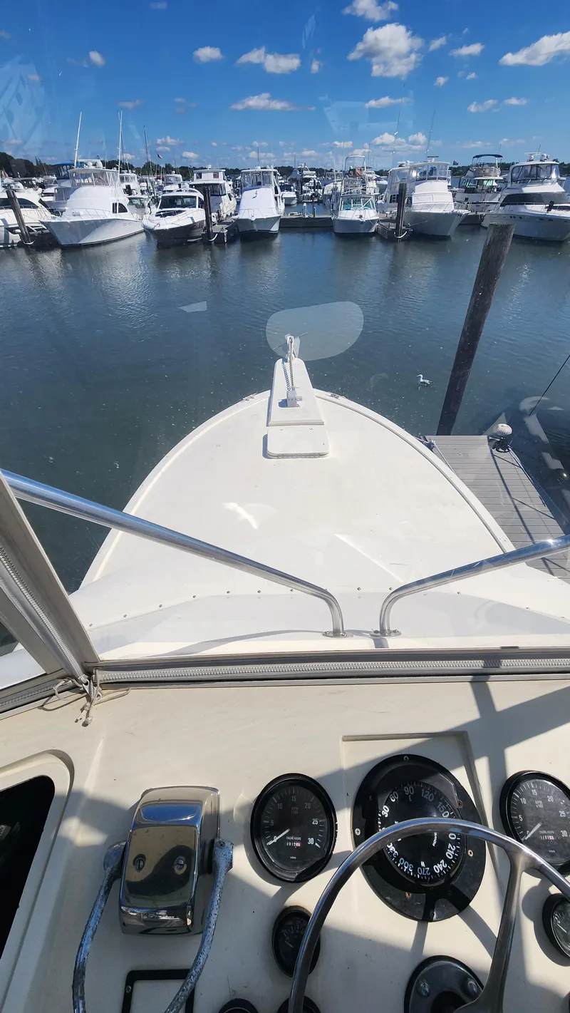 Slide: The Image of 1969 Hatteras 36 Sport Fisherman at marina, view from helm, clear sky. - 13