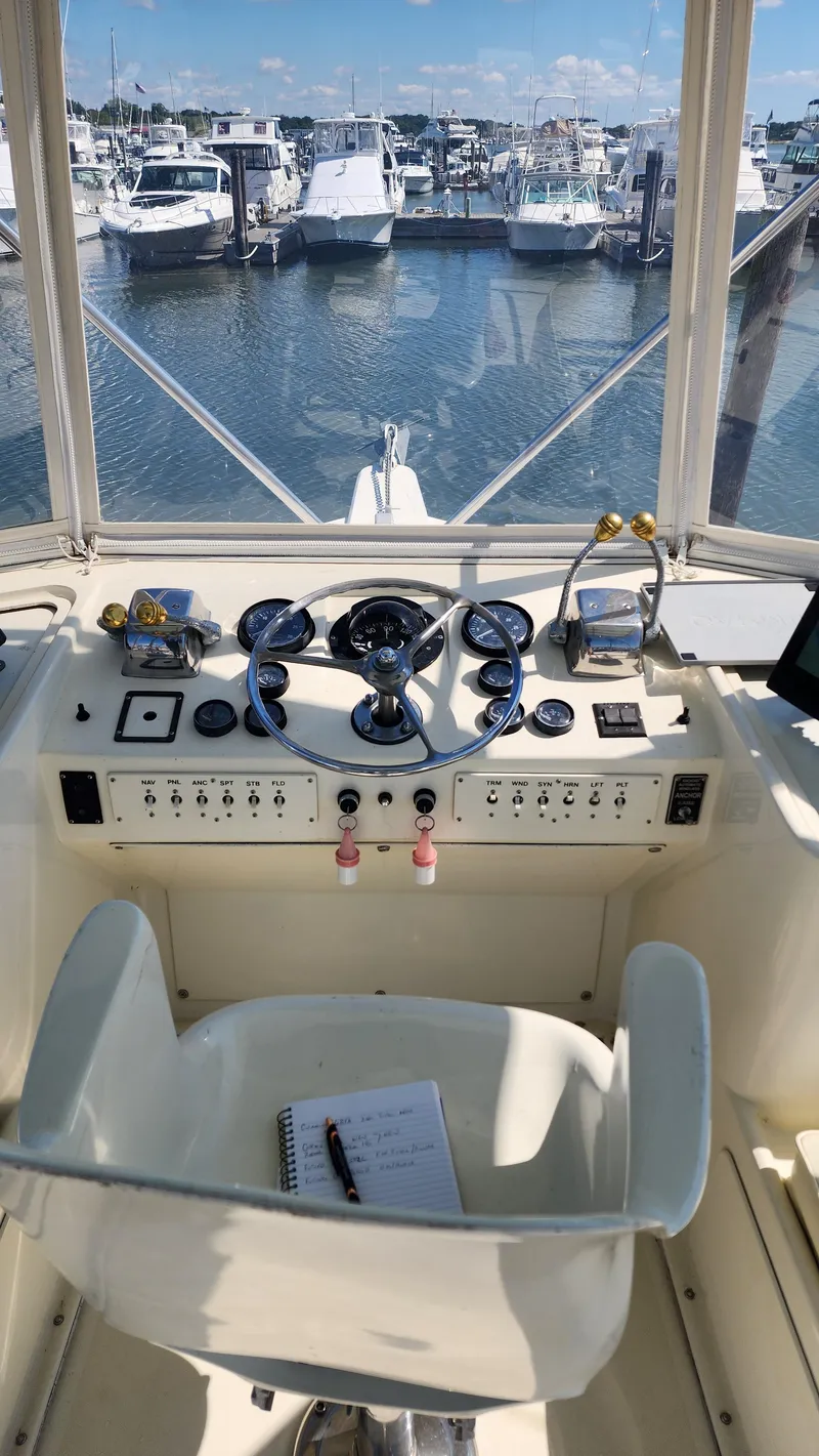 Slide: The Image of 1969 Hatteras 36 Sport Fisherman helm with marina view, featuring classic controls and gauges. - 14