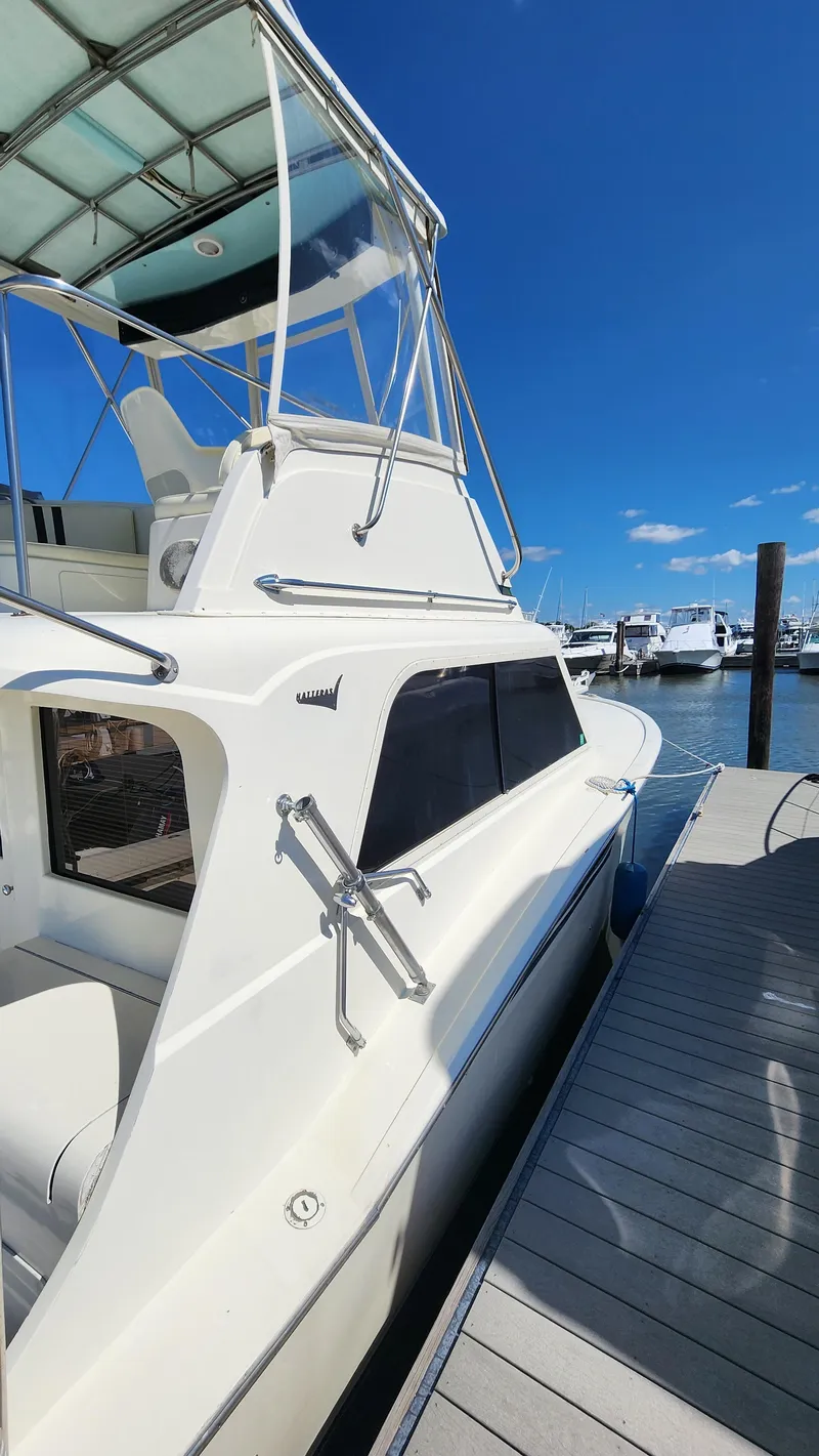 Slide: The Image of 1969 Hatteras 36 Sport Fisherman docked under clear blue sky. - 2