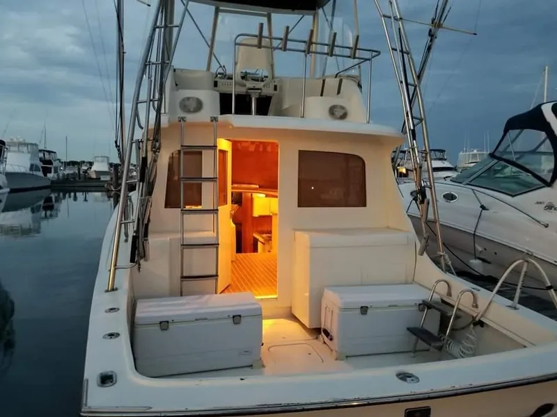 Slide: The Image of 1969 Hatteras 36 Sport Fisherman boat docked at marina, illuminated interior, evening setting. - 20