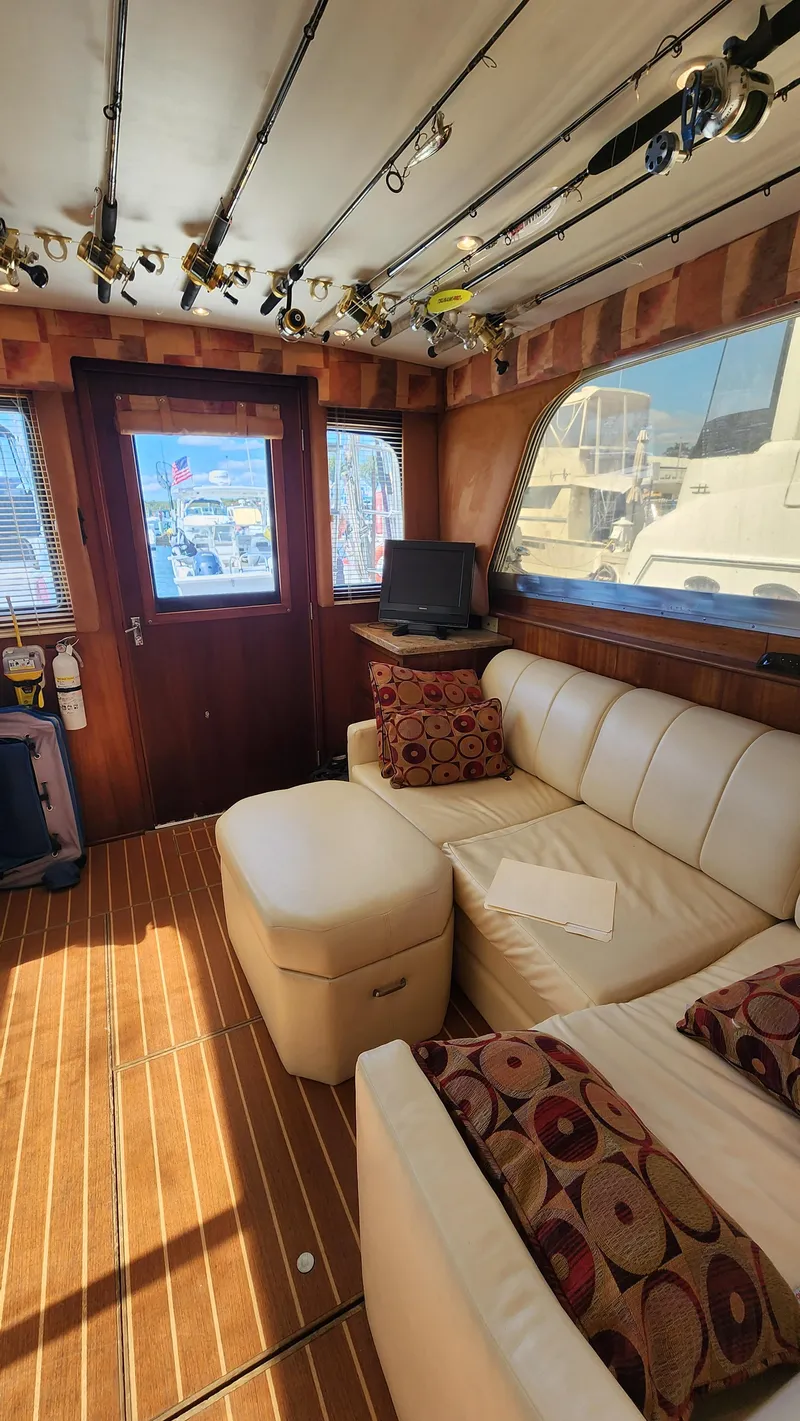 Slide: The Image of 1969 Hatteras 36 Sport Fisherman interior with beige seating and fishing rods. - 22